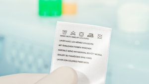 Kolorowe metki z różnymi symbolami prania na różnych tkaninach